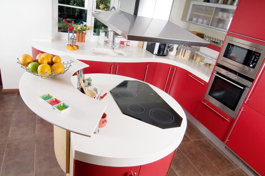 Kitchen with bi-level counter with round base, built in cooker and red base drawers