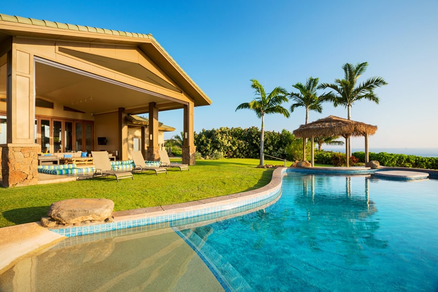 Swimming pool with faux sand and palapa
