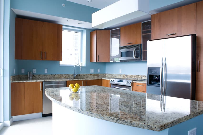 Trendy kitchen with blue walls, brown cabinets and island