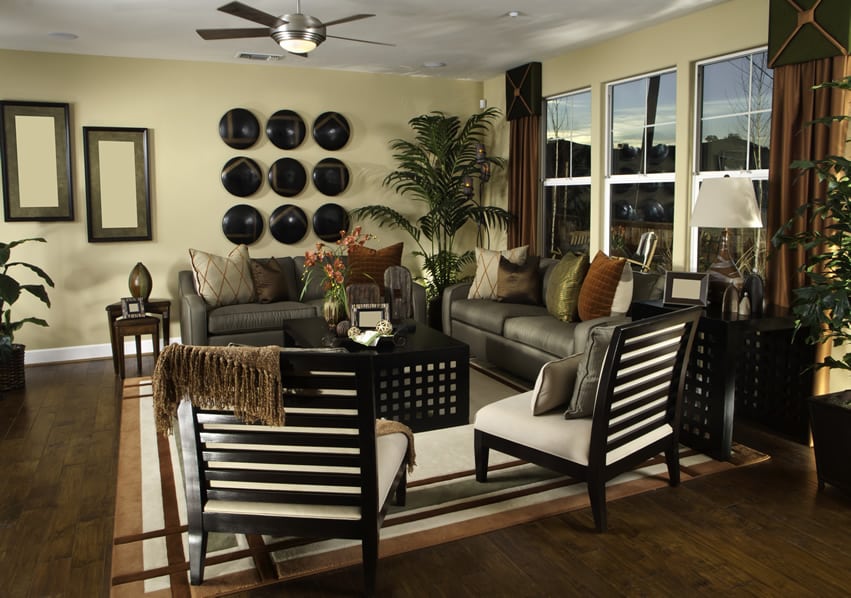 Room with yellow walls, wood wall art and ceiling fan