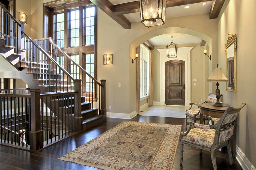 Arched foyer entry to home with stairs and large area rug