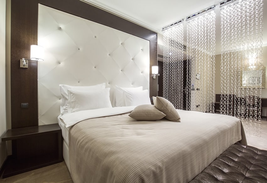 Attractive bedroom with large leather headboard chain curtain