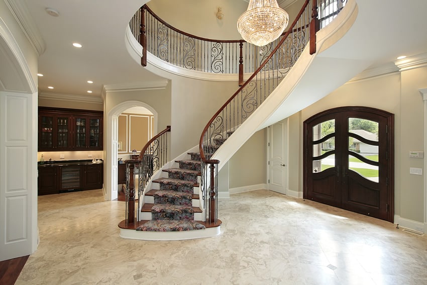 Polished handrails made of red wood, white walls with view of the kitchen counter