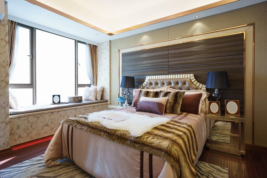 Bed with gold framed headboard and wood flooring