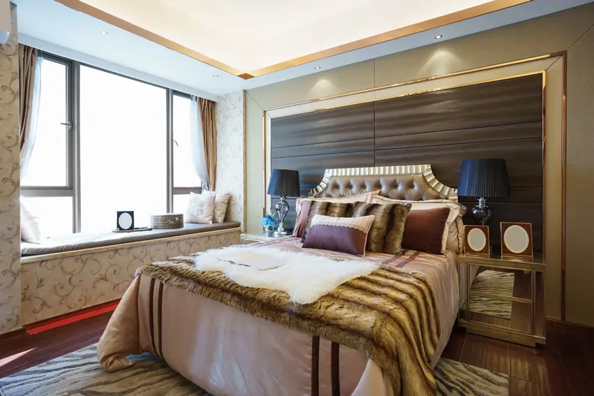 Wall paper with gold patterns, black lampshades and cushioned bay window
