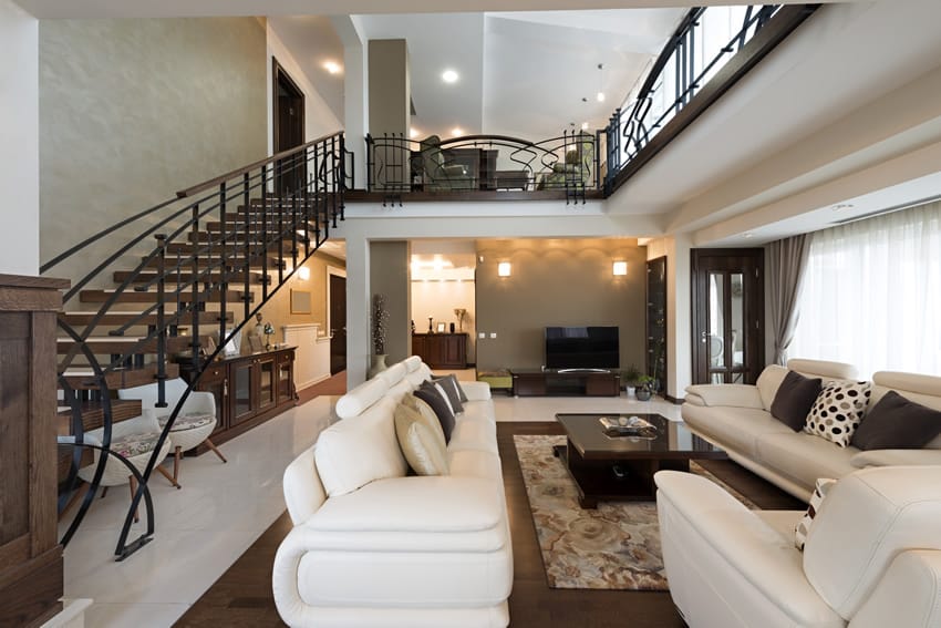 Staircase with wrought iron railings and wood steps and white leather upholstery 