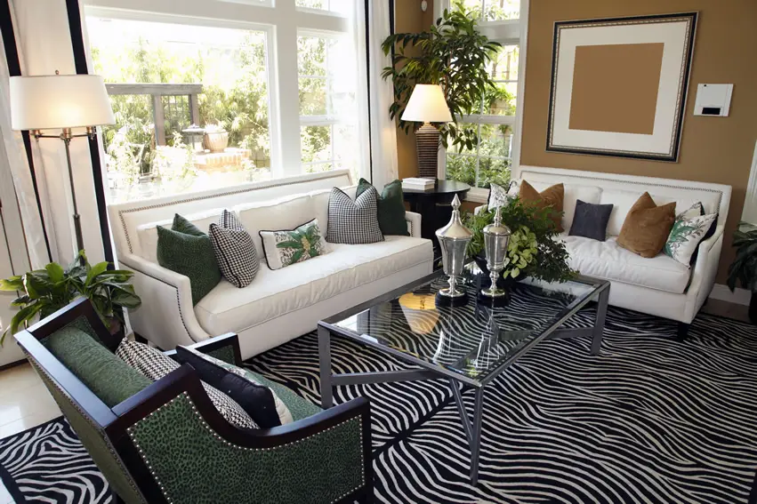 Statement carpet with zebra print, white floor lamps and green wingback chair
