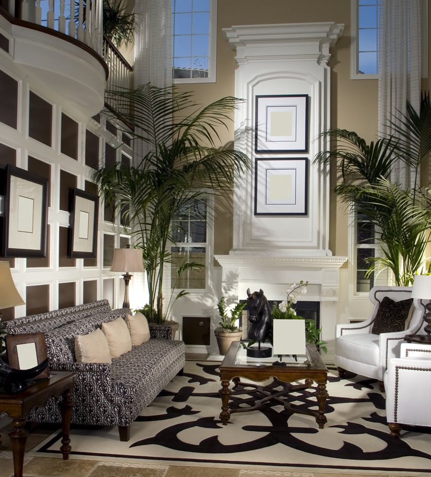 Room with printed upholstery, white wing chairs and oak side tables