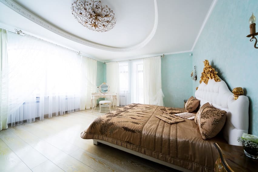Designer bedroom with light blue walls sheer curtains