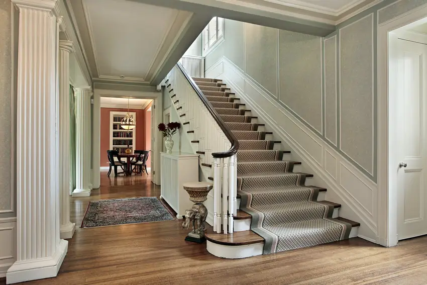 Foyer with columns, staircase and hardwood flooring