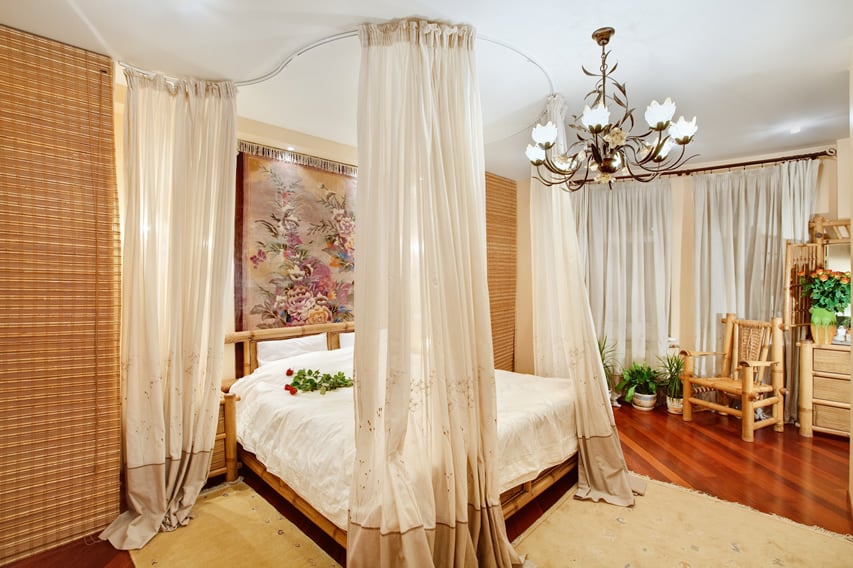 Bed with bamboo frame, roll-up blinds and oriental painting