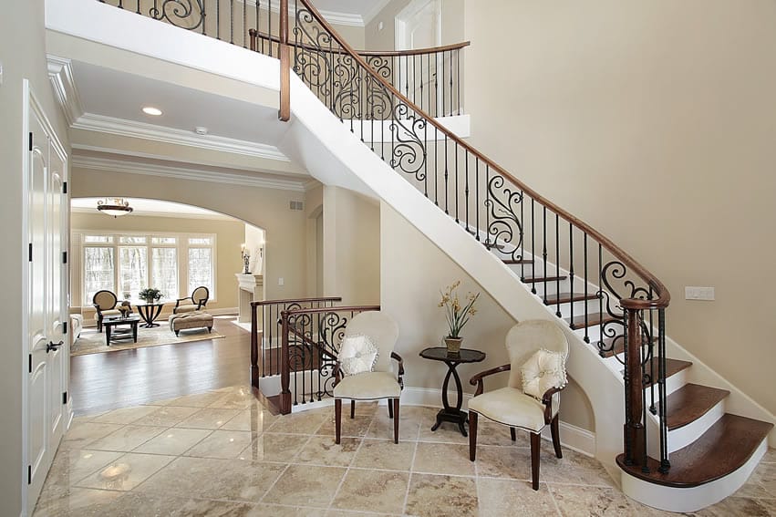 Foyer living room with wood stairs, wrought iron bannister, and elegant furniture