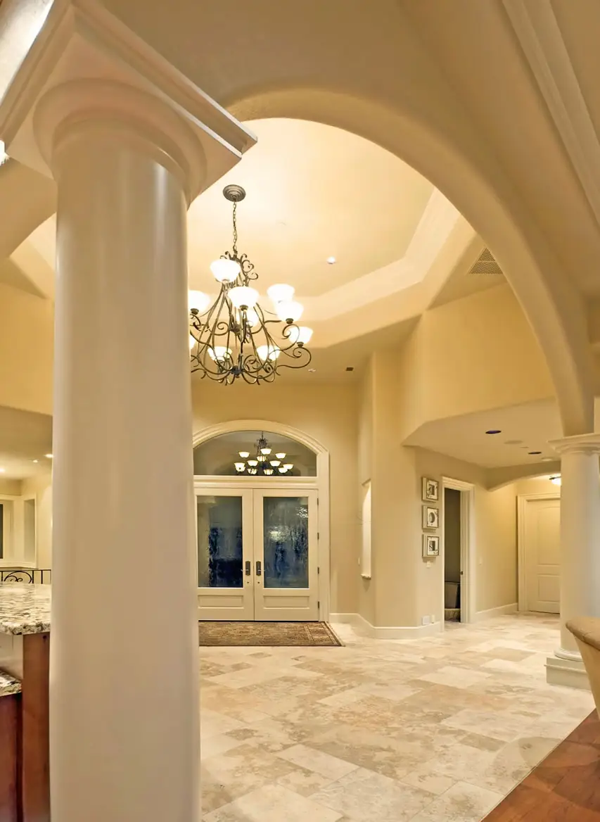 Entryway with tray ceiling and decorative pillars