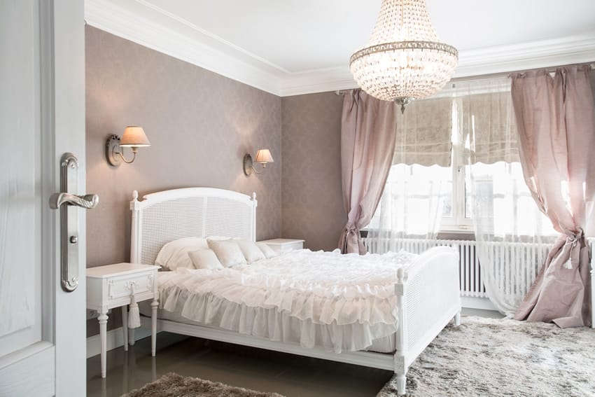 Lilac walls with ruffled bed cover and crystal chandelier