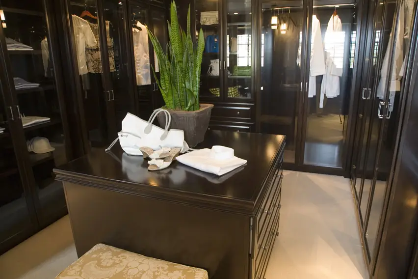 Closet with white robes and wood island accent