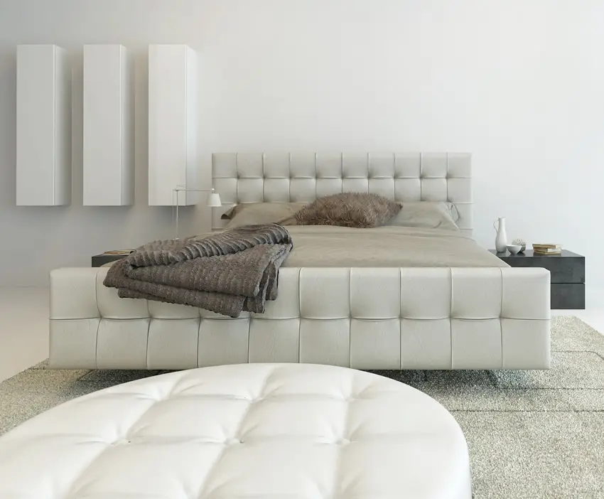 Bedroom wiht leather headboard and frame and complemented by white ottoman