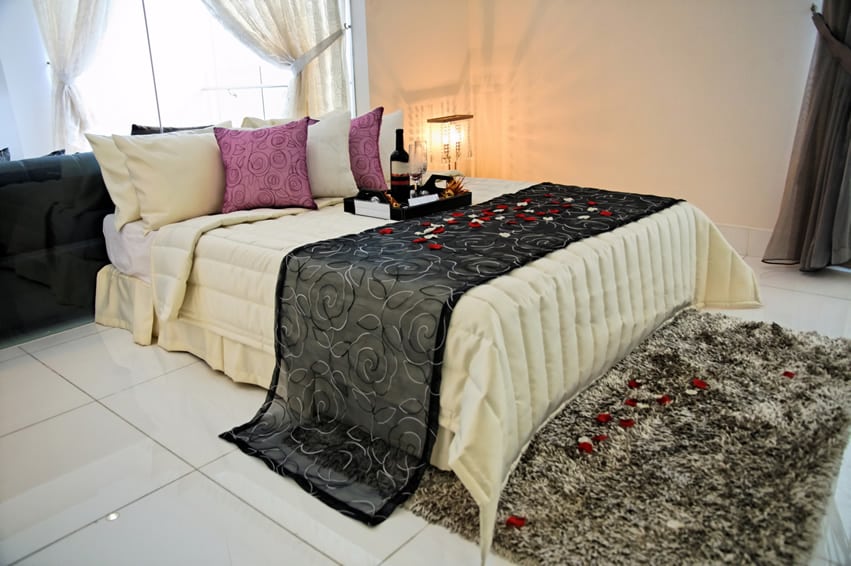 Romantic bedroom with wine and rose petals