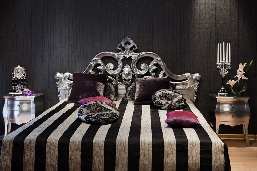 Black bedroom with silver bed frame and striped bed sheets