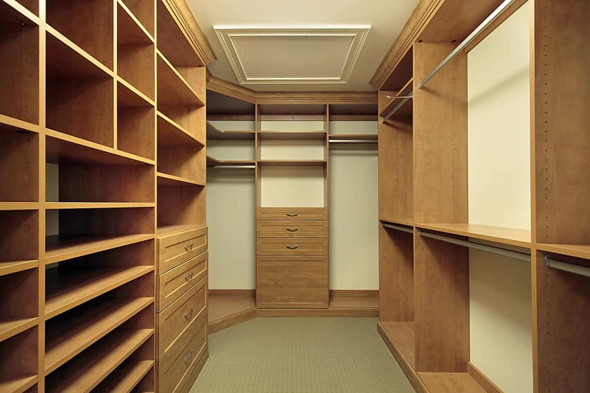 Walk in closet with shoes shelving and chest of drawers