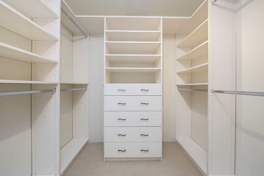 White walk in closet with dresser