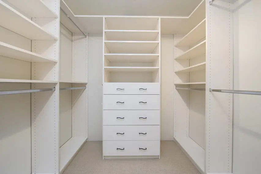 White cabinets with two hanging rods for clothes