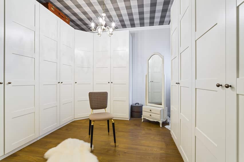 Large walk in closet with floor to ceiling wardrobe and chandelier