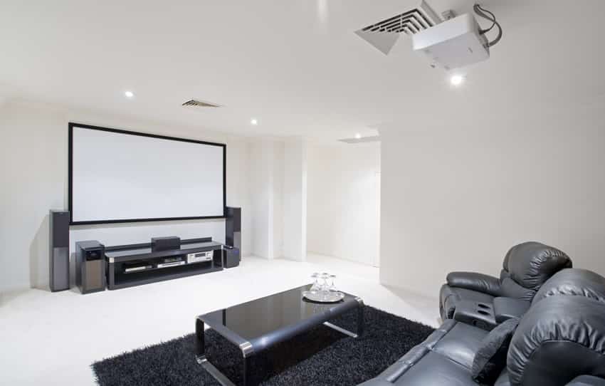 room with projector screen and black leather couch and recliner