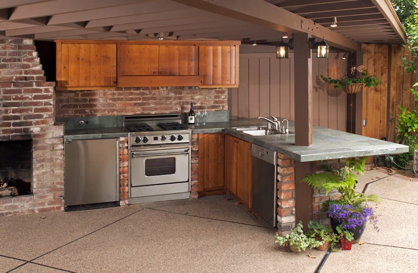Outdoor kitchen with brick fireplace and wood cabinets
