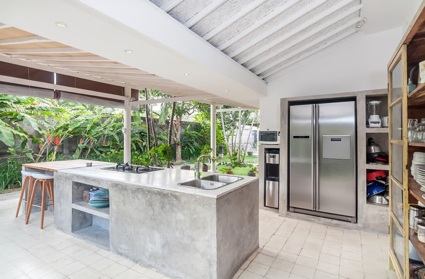 Concrete island with steel refrigerator in an outdoor setting