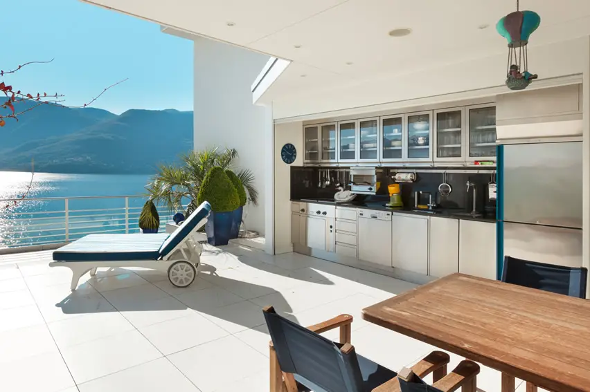 Kitchen with white cabinets, lounge chair and lake view