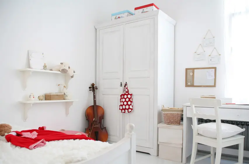 White wardrobe in bedroom with matching furniture