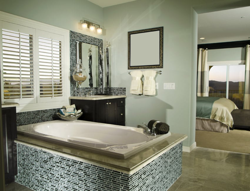 Master bath suite with bathtub with intricate tile work