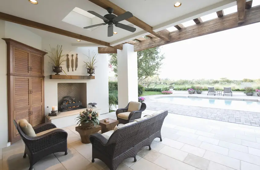 Beautiful backyard fireplace at luxury home overlooking swimming pool with ceiling fan