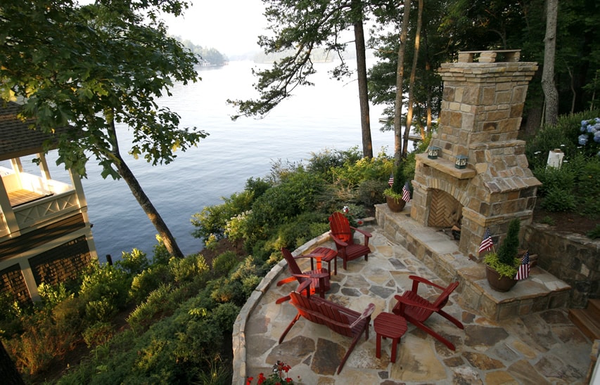 Beautiful outdoor fireplace seating area with lake view