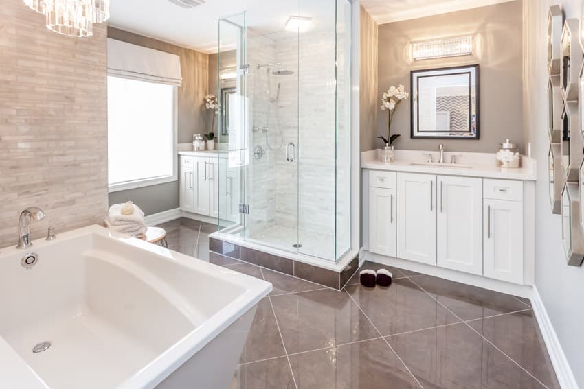 Bathroom with chandelier, oatmeal painted walls and square mirrors