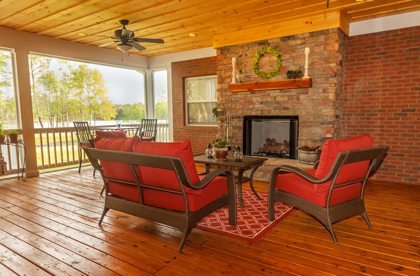 Covered deck with outdoor fireplace with lake view