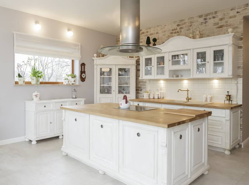 Custom white kitchen with wood butcher block counters and farmhouse style design.