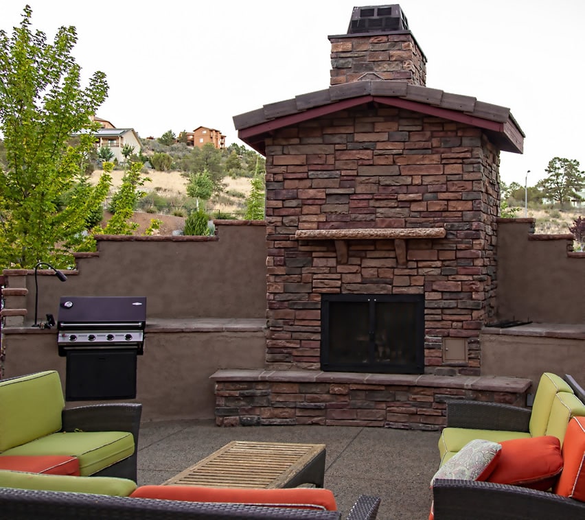 Large stone fireplace in back yard of home