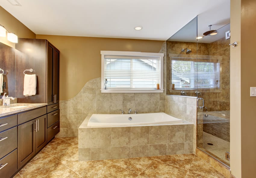 Bathroom with mahogany cabinets with chrome handles and shower with half-glass divider and