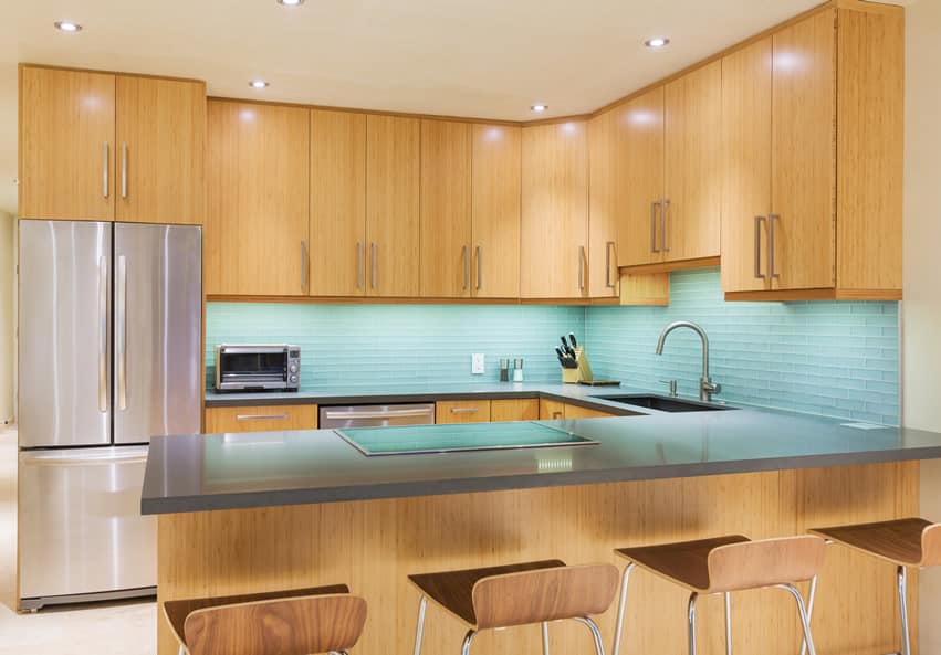 Light wood cabinet kitchen with blue tile back splash