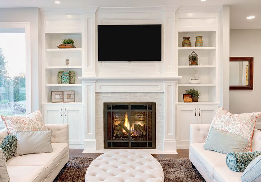 Living room with built in book shelves and white furniture with ottoman