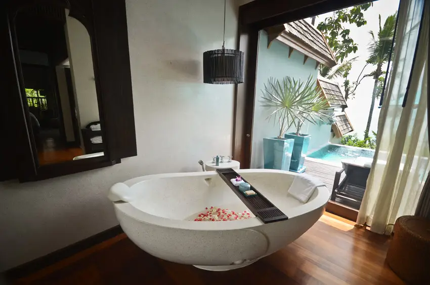 Bathroom with dark wood window frames and tiles with bean-shaped tub
