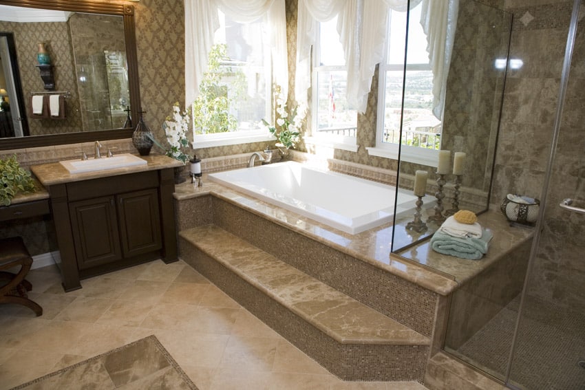 Bathroom with walnut cabinets, patterned wall paper and bathtub with glass wall
