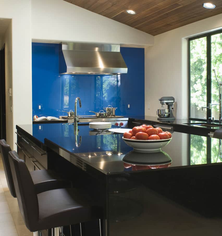 Kitchen with blue painted backsplash, breakfast island and windows