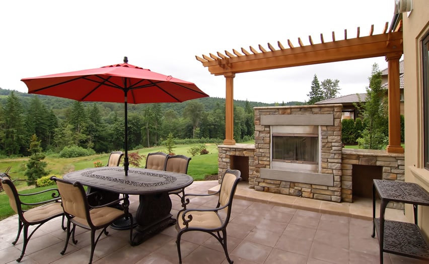 Outdoor fireplace with stone enclosure and pergola