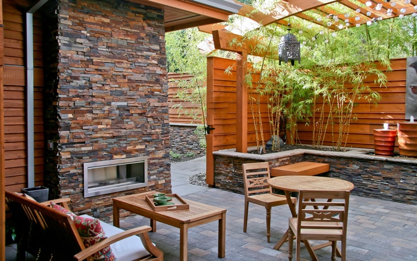 Outdoor slate fireplace with pergola on patio