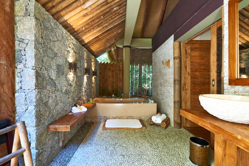 Rustic luxury bathroom with exposed stone wall