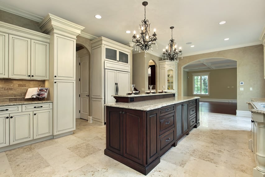 Upscale white kitchen with two chandeliers