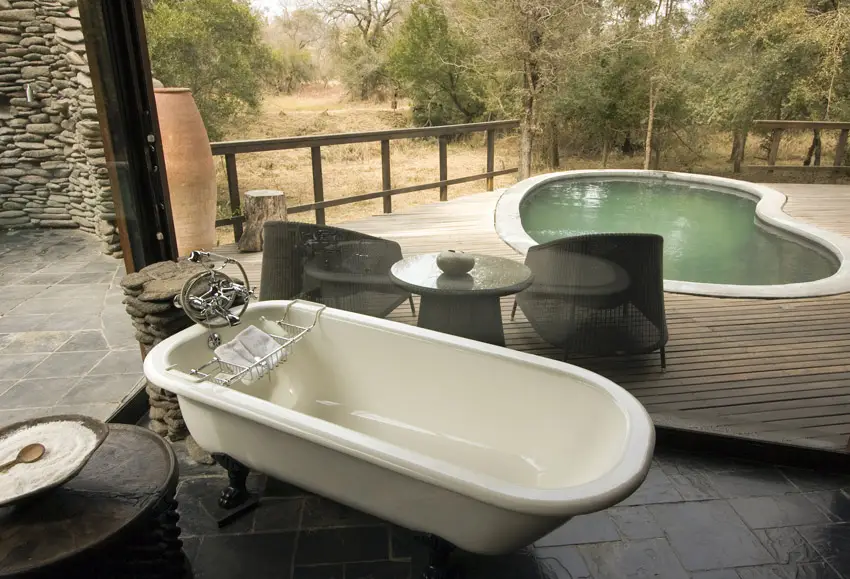 Bathtub overlooking private pool at African lodge