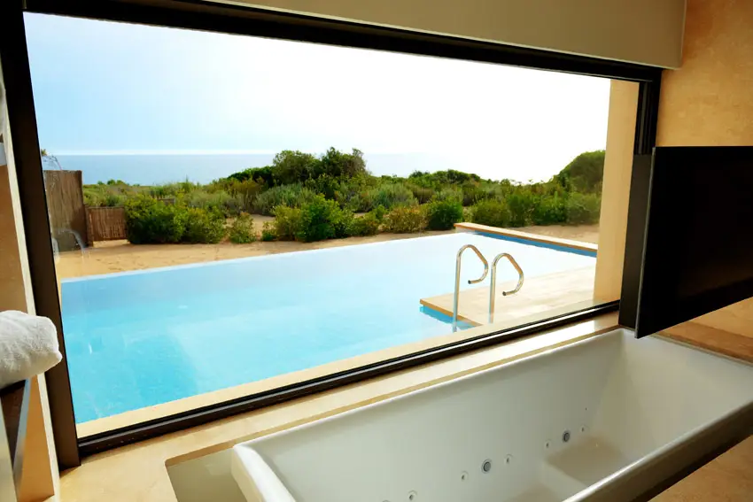 Jetted bathtub with pool and ocean view